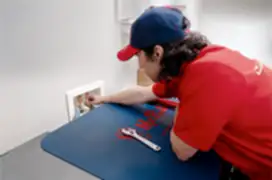 Mr. Rooter technician fixing a water valve in a laundry room.