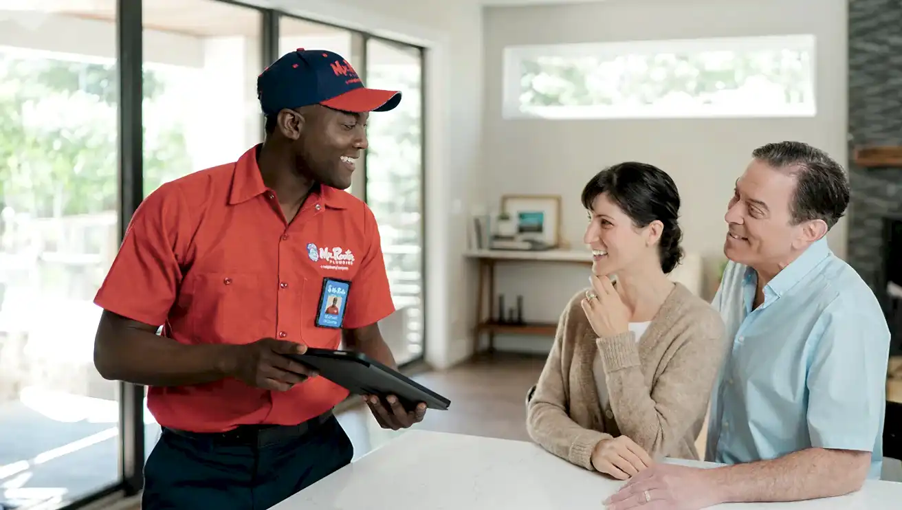 Two Mr. Rooter customers speaking with a technician about water shut off services.